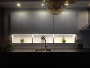 a kitchen with a sink and white cabinets with green vases at Villa van Brienen in Dilsen-Stokkem