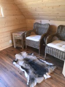 um quarto com duas cadeiras e uma mesa com um tapete peludo em Fjäll Stuga em Steninge