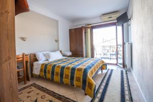 a bedroom with a bed with a yellow and blue blanket at Holiday Zigos in Igoumenitsa