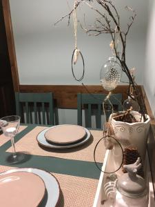 einem Tisch mit Platten und einer Vase darauf in der Unterkunft Decor Park Apartament in Karpacz