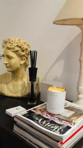 a desk with a bust and a lamp and books at Alda Casa De Los Reyes in Toledo +78 photos
