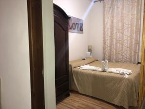 1 dormitorio con 2 camas y puerta con toallas en Casa Vacanze Salinisti en Marsala