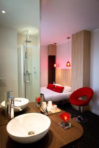 a bathroom with a sink and a bedroom with a bed at Best Western Plus Hotel Plaisance in Villefranche-sur-Saône