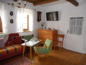 uma sala de estar com um sofá, uma mesa e cadeiras em Slovácká chalupa em Ratíškovice