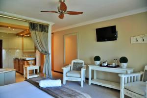 a bedroom with a bed and a tv on the wall at Stirling Manor Boutique Guest House in Hartbeespoort