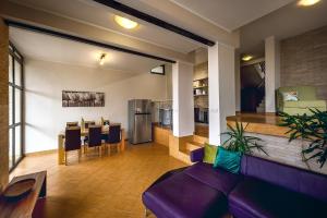a living room with a purple couch and a kitchen at Villa Milana Budva in Budva