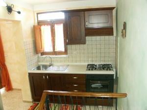 Casa Di Nonna Pina في مارينا دي كاميروتا: مطبخ صغير مع موقد ومغسلة