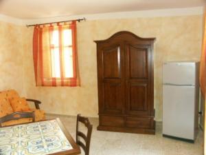a kitchen with a table and a refrigerator in a room at Casa Di Nonna Pina in Marina di Camerota