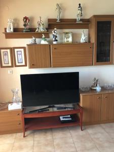 a large flat screen tv on a wooden entertainment center at Malibu Playa Apartamento in Benalmádena