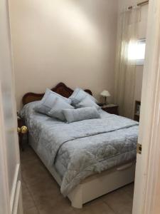 貝納爾馬德納的住宿－Malibu Playa Apartamento，一间卧室配有带白色床单和枕头的床。