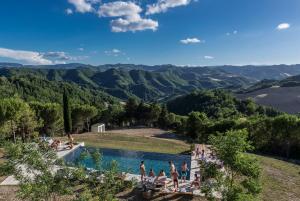 a group of people standing around a pool in the mountains at Il Pavone Errante in Ciola