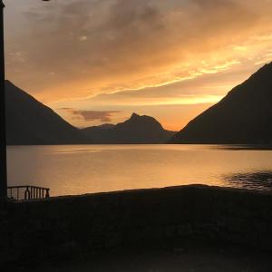 una puesta de sol sobre un cuerpo de agua con montañas en Milly Lake, en Claino