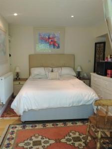 1 dormitorio con 1 cama grande con sábanas blancas en Sunny Patch, en Stroud