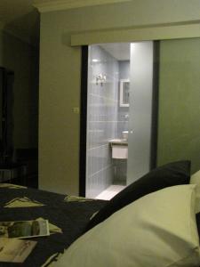 a bathroom with a bed and a sink and a mirror at BreizH HoteL in Crach