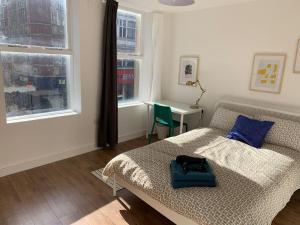 a bedroom with a bed with a blue bag on it at GRANBY APARTMENTS F-6 in Leicester