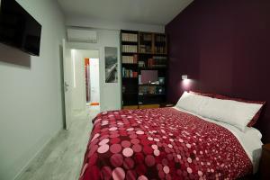 Schlafzimmer mit einem Bett mit einer roten und weißen Tagesdecke in der Unterkunft Posada de Liz y Fabrizio in Rom