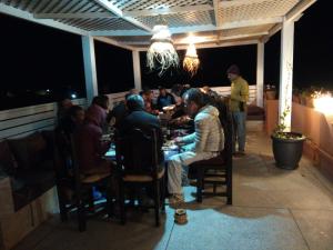 un groupe de personnes assises à une table dans un restaurant dans l'établissement ITRANE GUEST HOUSE, à Mirleft