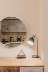 a mirror on the wall above a desk with a lamp at Best House, Central Luxury Apartment, Agiou Nikolaou, Patra in Patra