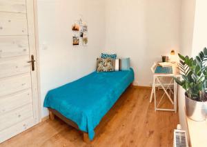 sypialnia z łóżkiem z niebieskim kocem w obiekcie Apartament NOTI Gdynia z parkingiem w mieście Gdynia