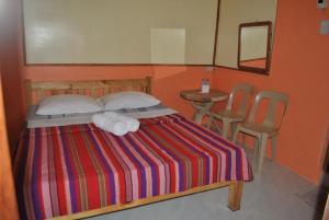1 dormitorio con 1 cama, mesa y sillas en Banaue Homestay, en Banaue