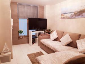 uma sala de estar com um sofá e uma televisão de ecrã plano em Residentie Ruytingen em Oostende