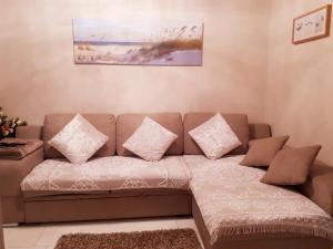 ein braunes Sofa mit Kissen im Wohnzimmer in der Unterkunft Residentie Ruytingen in Ostende