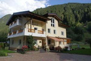 a large building with a mountain in the background at Apart Auhof in See