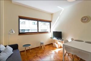 sala de estar con sofá, mesa y TV en Studio 312 - With Free Parking, en Oporto