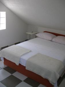 a bedroom with a large bed with white sheets at Apartment Ivan - beautiful sea view in Splitska