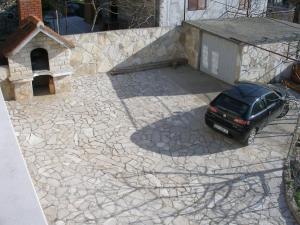 a black car parked on a stone driveway at Apartment Ivan - beautiful sea view in Splitska