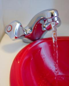 a red sink with water coming out of a faucet at The Dolby Hotel Liverpool - Free city centre parking in Liverpool