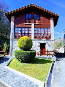 a house with a bush in front of it at La Quintana de Doña Leonor in Arriondas