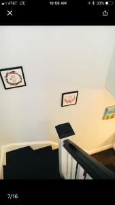 a staircase with three pictures on a white wall at Best Bedroom Next to JHU in Baltimore