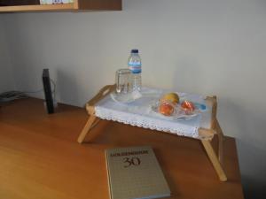 a small table with a bottle of water and fruit on it at Quarto junto ao mar in Matosinhos