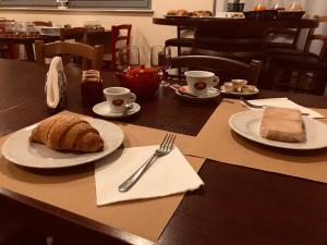 un tavolo con un piatto di pane e tazze di caffè di Rosso Di Sera a Città Sant'Angelo