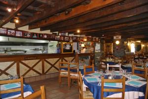 a restaurant with tables and chairs and a kitchen at L 'Annexe in Lohéac