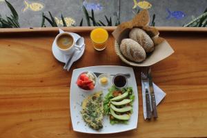 a table with a plate of food with eggs and bread at Posada del Mar in Puerto Ayora