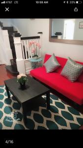 a living room with a red couch and a table at comfort & charm in the johns hopkins uni in Baltimore