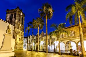 a building with palm trees and a clock tower at Casa Emblemática Salgado in Santa Cruz de la Palma