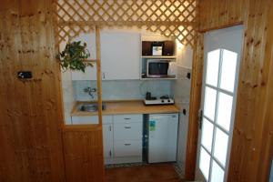 a small kitchen with white cabinets and a sink at Mecsek üdülő ingyenes klímával 300 m-re a fürdőtől in Harkány