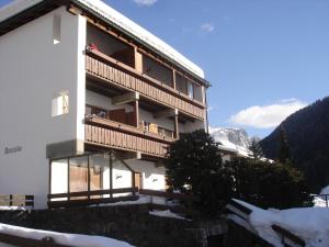 a building in the mountains with snow on the ground at Appartment Ansciuda in Selva di Val Gardena
