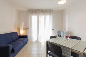 a living room with a blue couch and a table at Appartamento Verona Fiera e Centro in Verona