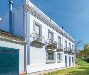 - un bâtiment blanc avec des balcons sur le côté dans l'établissement Finca San Juan Alojamiento Boutique, à Constantina