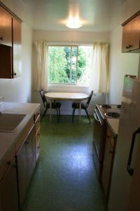 a small kitchen with a table and a window at Portland Value Inn & Suites in Portland