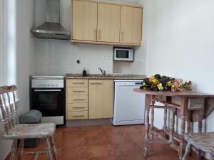 a kitchen with white appliances and a table with flowers on it at Casa da American Cable Company in Horta