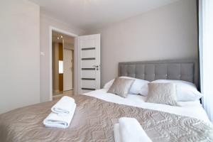 Un dormitorio con una cama grande con toallas. en Apartament Exclusive Centrum, en Białystok