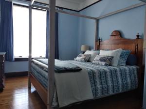 a bedroom with a canopy bed with pillows at Casa da American Cable Company in Horta