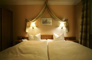 2 Betten in einem Hotelzimmer mit weißen Kissen in der Unterkunft Hotel Grüne Tanne Mandelholz in Elend