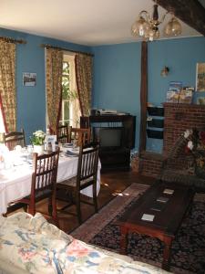 een woonkamer met een tafel en een open haard bij Rothmans B&B in Chelmsford