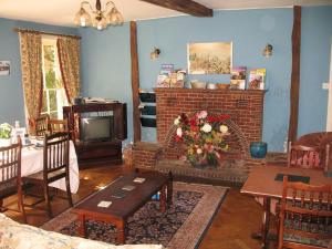 a living room with a fireplace and a tv at Rothmans B&B in Chelmsford